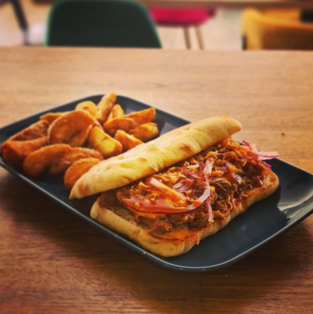 Pulled Pork servida en Focaccia Italiana con cheddar y BBQ